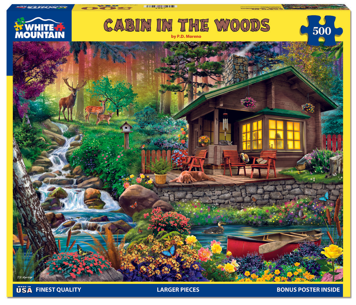 A 500 piece jigsaw puzzle depicting a cabin in the woods with a family enjoying dinner in front, while deer look on from the forest. The puzzle is marked with 'White Mountain' branding and has a bonus poster inside.