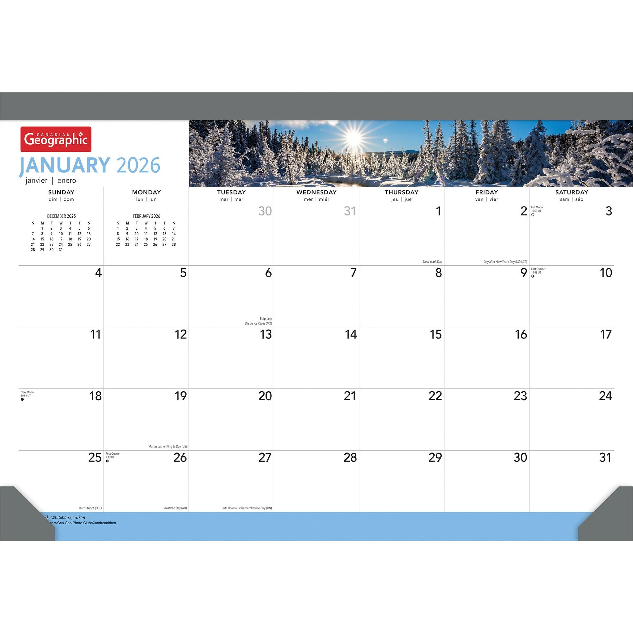 A desk pad calendar for January 2026 featuring a scenic view of a frozen landscape with trees and snow, and the sun shining brightly.