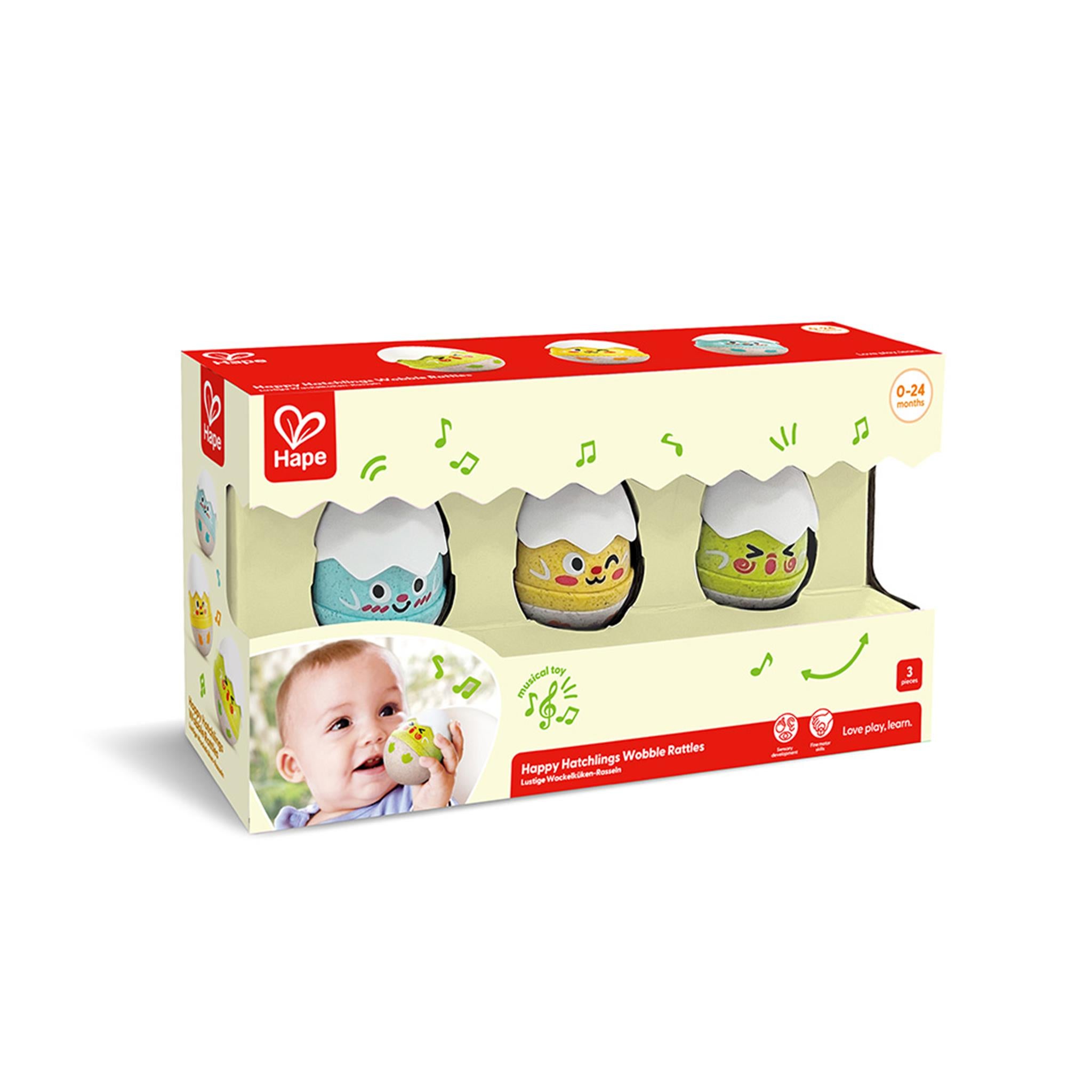 A set of three colorful wobble rattles designed to look like eggs with facial expressions, packaged in a cardboard box with a baby on the front by Hape.