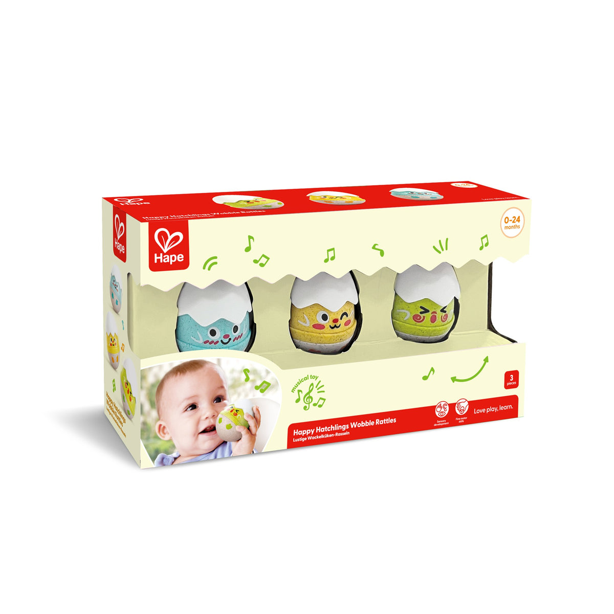 A set of three colorful wobble rattles designed to look like eggs with facial expressions, packaged in a cardboard box with a baby on the front by Hape.