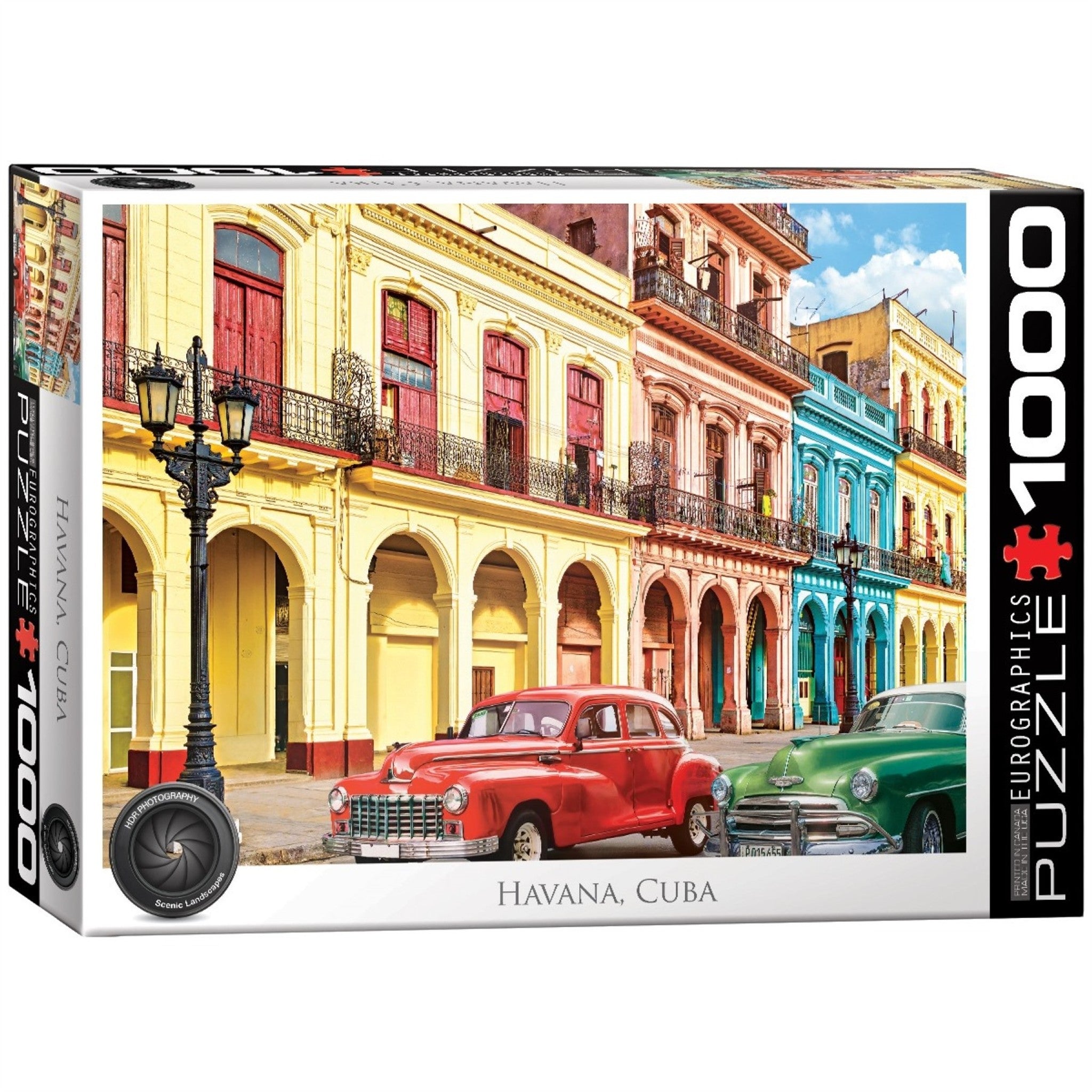 A view of pastel coloured buildings in Havana Cuba with two classic cars on the street.