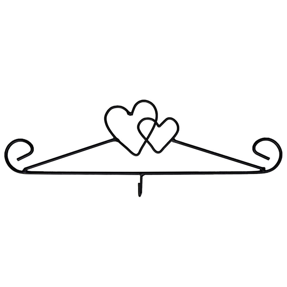 A wrought iron hanger with a heart shape design, primarily black in color.