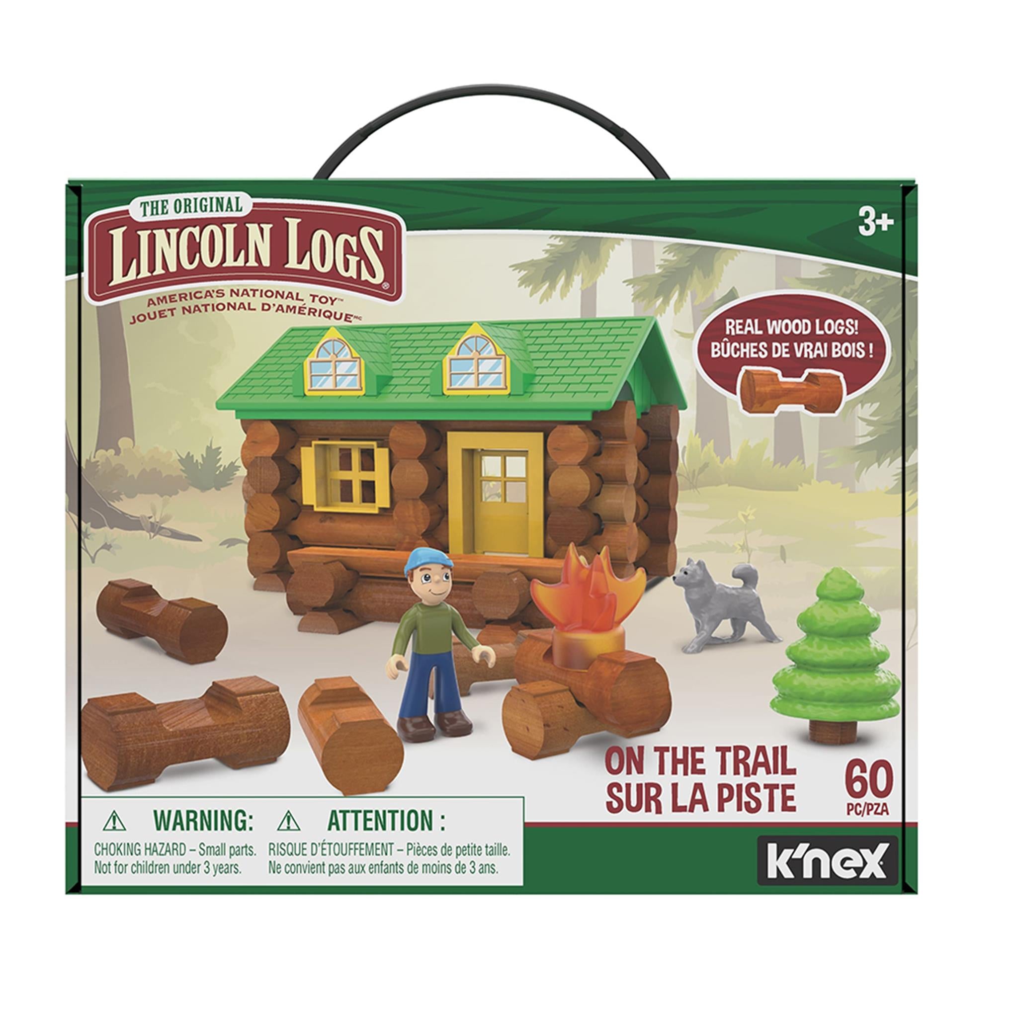 Packaging for 'Lincoln Logs On The Trail 59pc' building set showing a log cabin scene with a green roof, yellow door, and a surrounding environment including a tree and a bonfire. The box also displays toy figures and the K'nex logo.