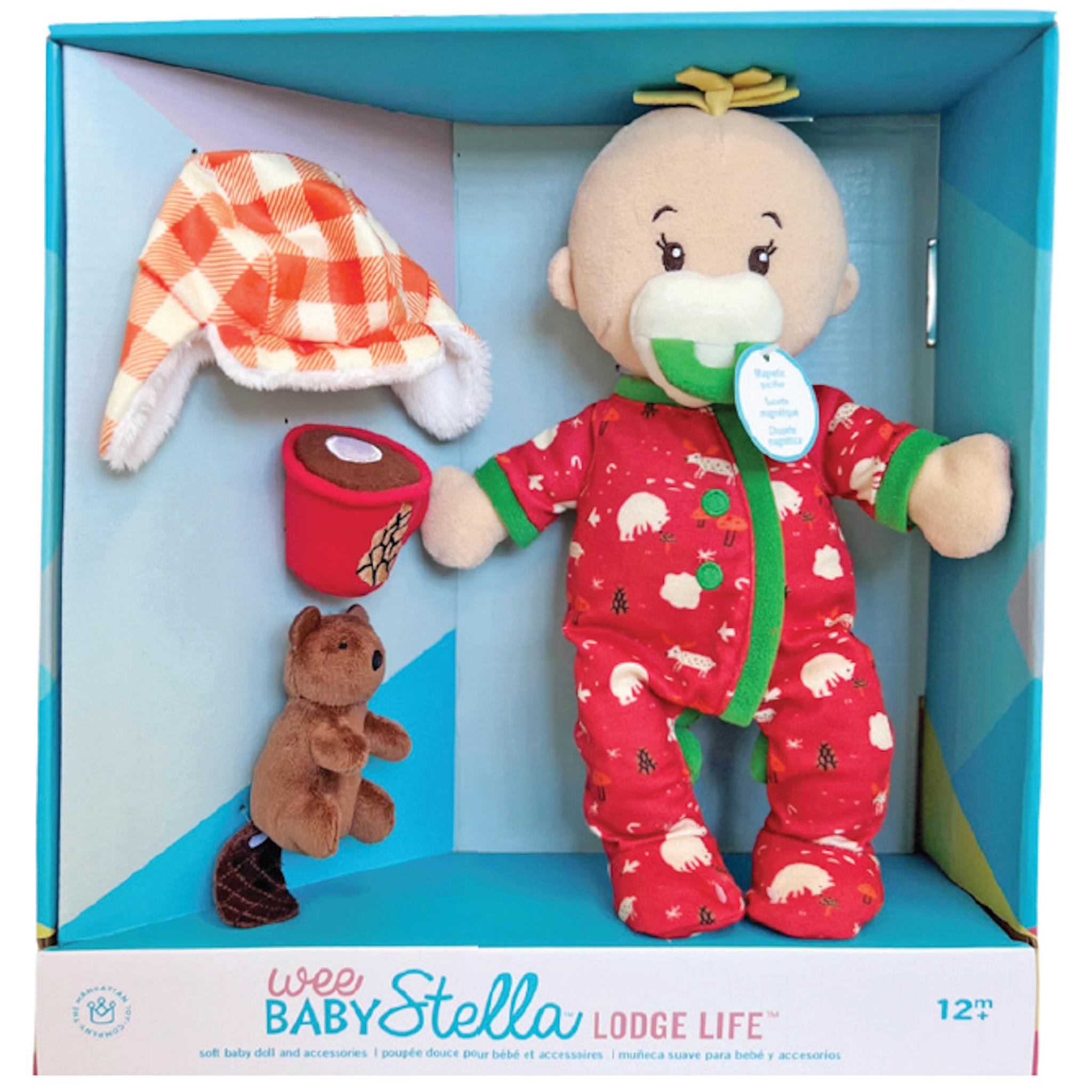 Wee Baby Stella Lodge Life doll set in packaging, showing a doll in a red onesie with a woodland animal print, accompanied by a trapper hat, a roll of toilet paper, and a small plush beaver.