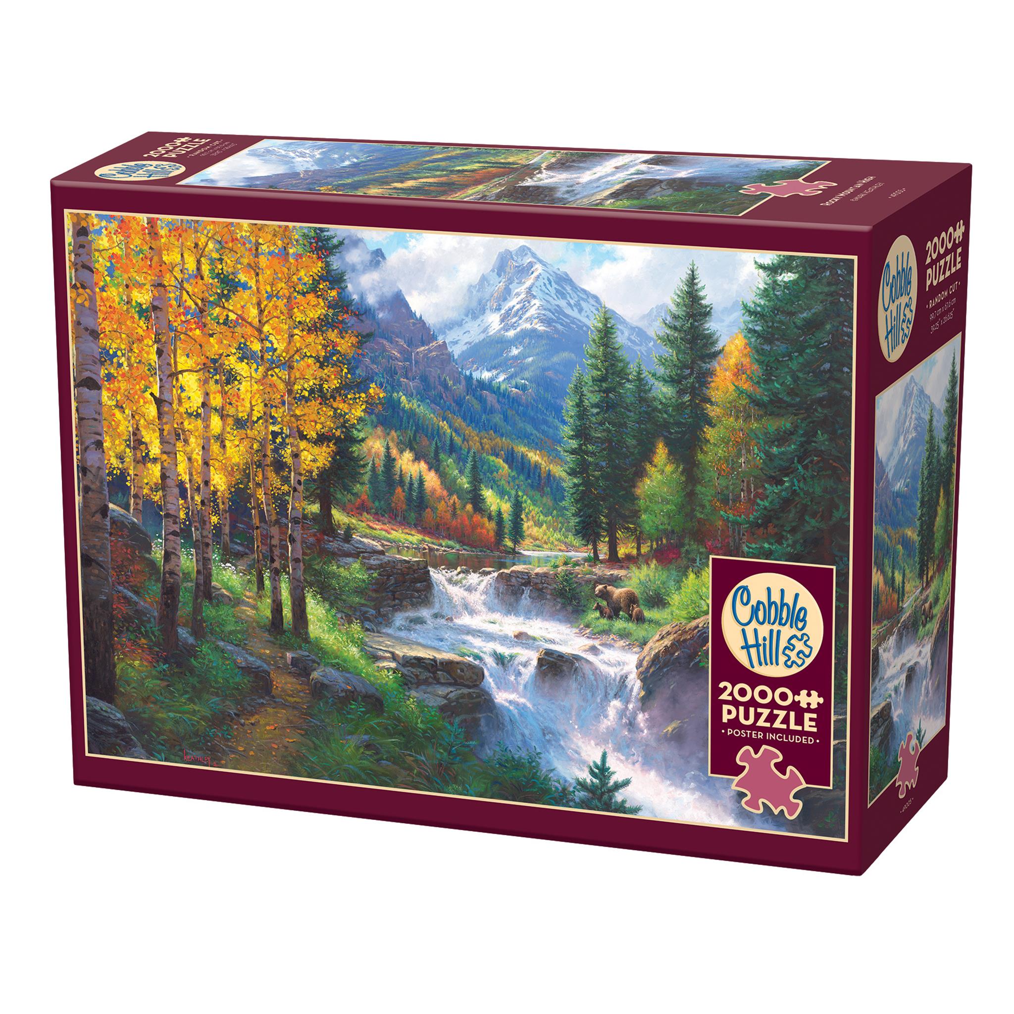 A 2000 piece Cobble Hill jigsaw puzzle box featuring a vibrant mountain landscape with autumn trees and a river.