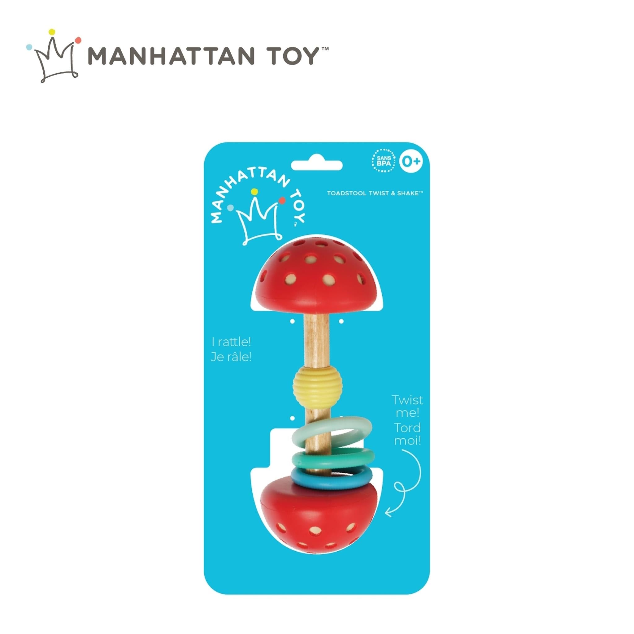 A multicolored baby toy in the shape of a toadstool with a red cap, white stem, and blue and yellow rings designed for twisting, shaking, and teething, packaged on a blue cardboard backing with the Manhattan Toy logo.