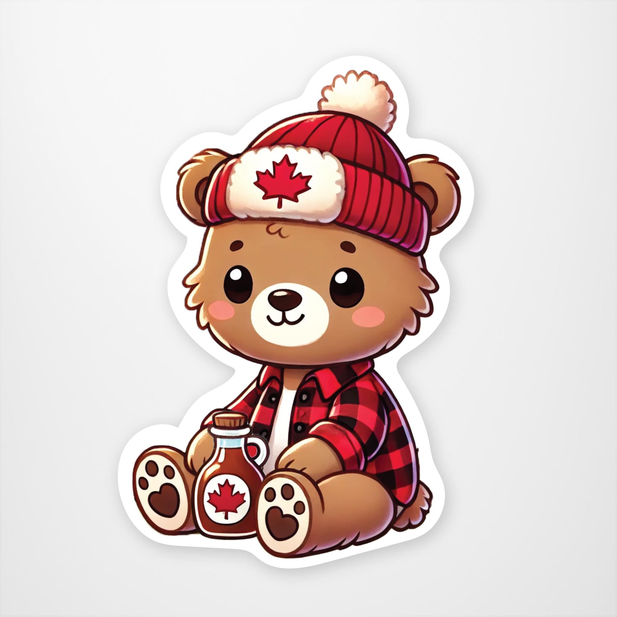 Brown teddy bear wearing red and white toque with maple leaf. Bear is wearing red and black plaid flannel shirt with bottle of maple syrup between it feet.