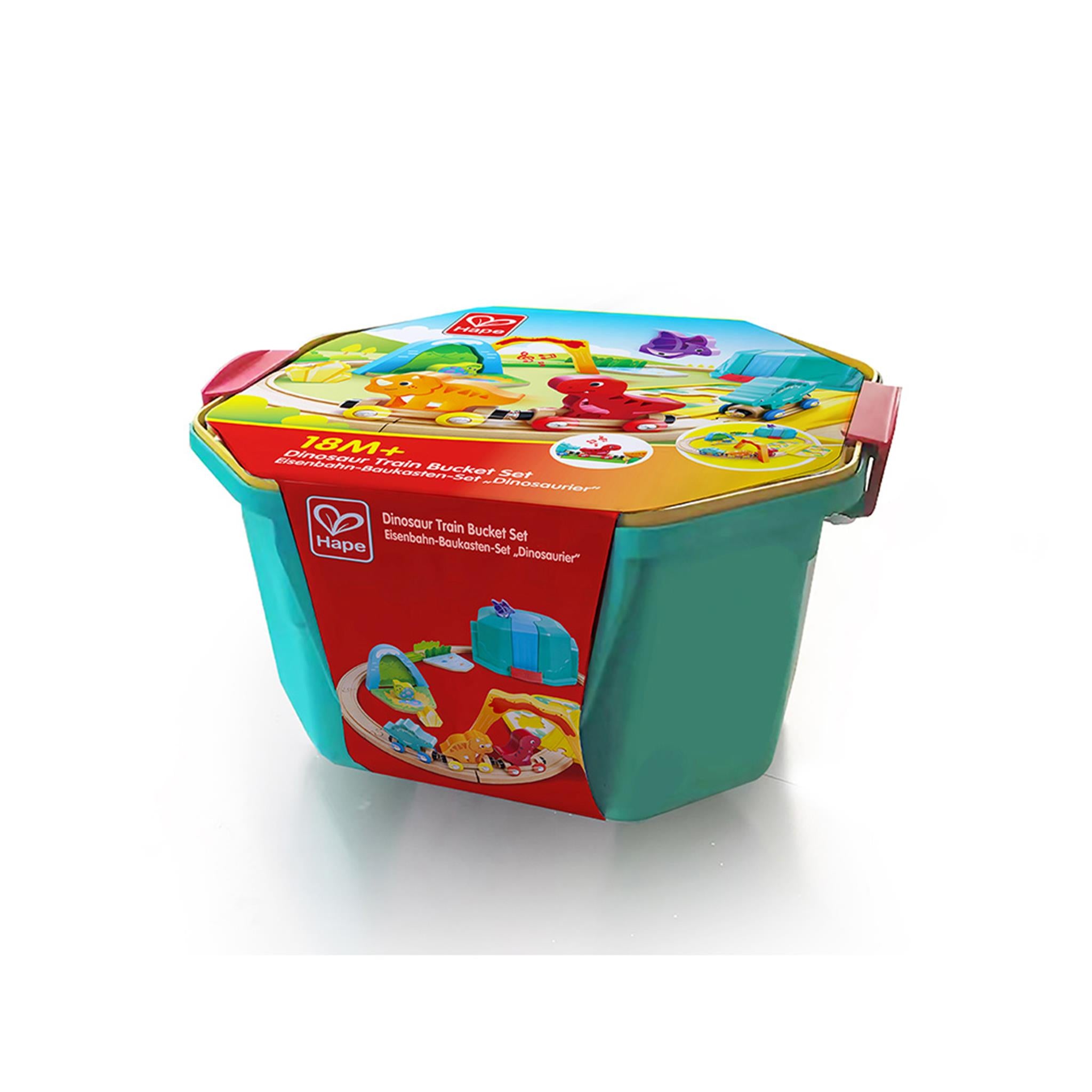 A colorful dinosaur train bucket set with multiple pieces, packaged in a clear plastic container with a green lid and a red label showing illustrations of the dinosaurs and train track.