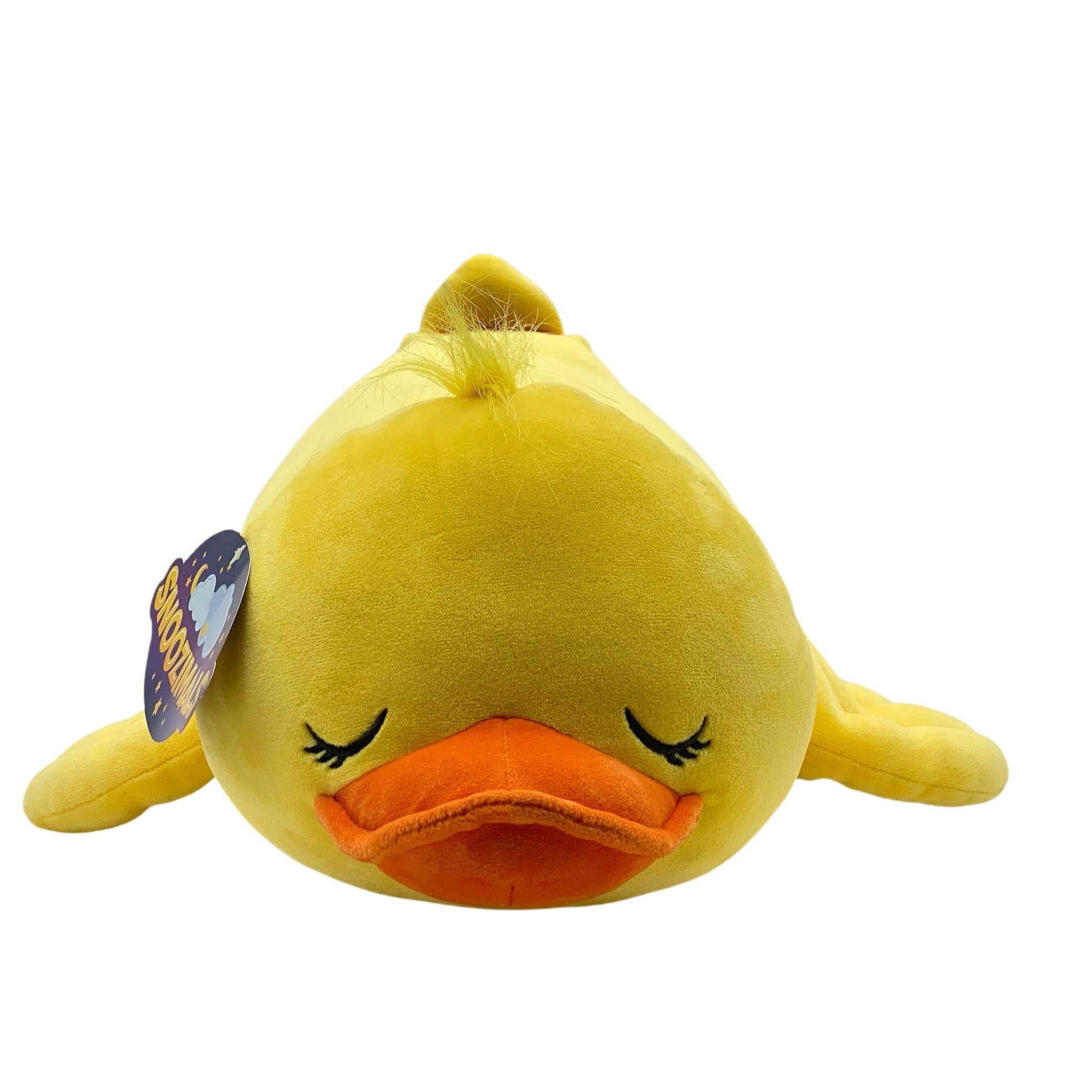A plush toy resembling a yellow duck with a stylized design, featuring a soft plush body with a tag attached.