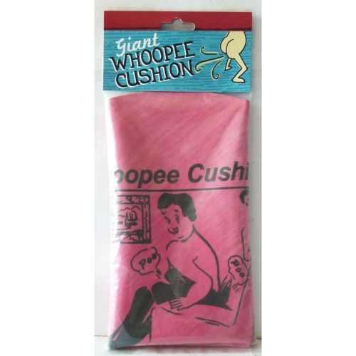 A packaged giant whoopee cushion with a picture of a person sitting on a cushion, predominantly pink in color with product details.