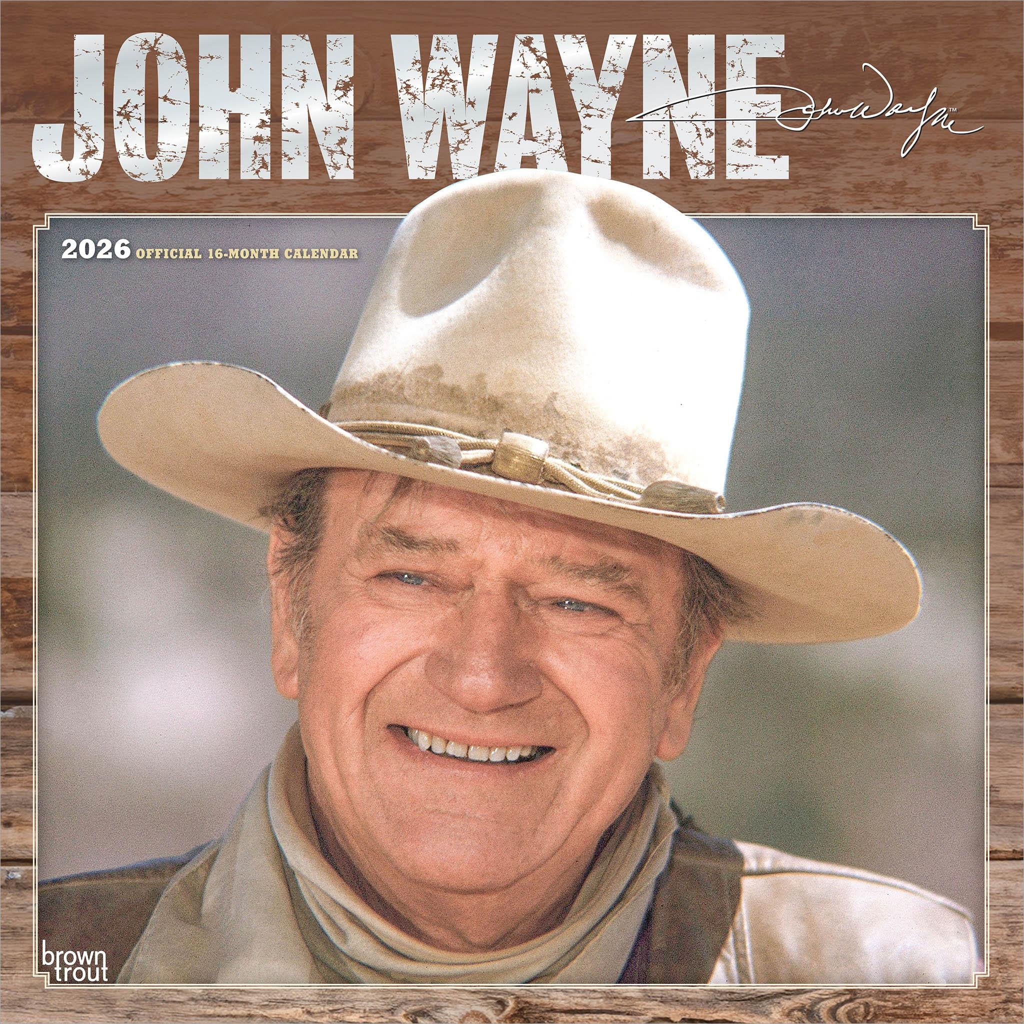 A wall calendar featuring an image of John Wayne wearing a cowboy hat, smiling, with a wooden background.