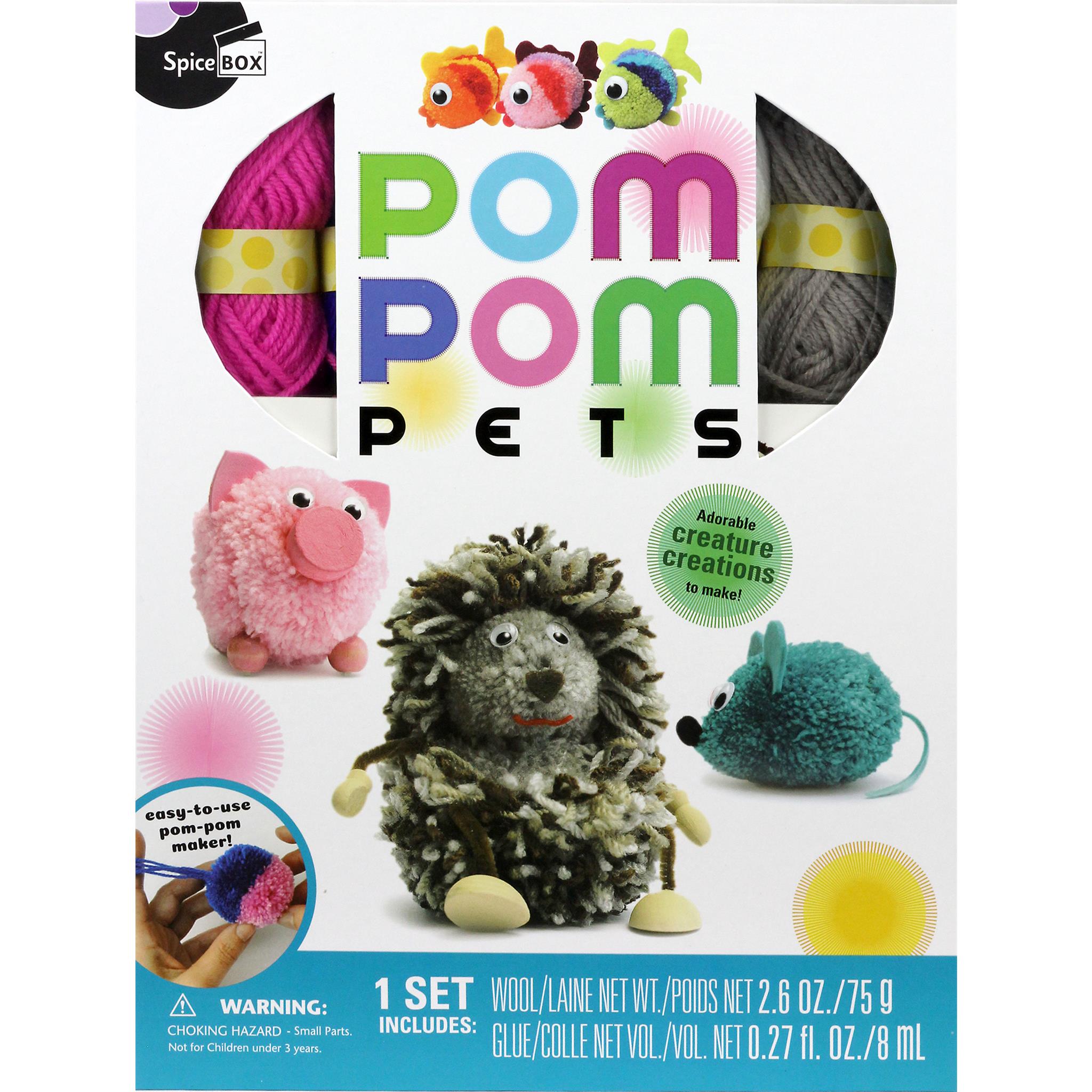 The image shows the cover of the 'Pom Pom Pets' craft kit, which includes a set of 3 pom-pom makers and various yarns and decorations to create different animals like a pink pig and a green hedgehog.