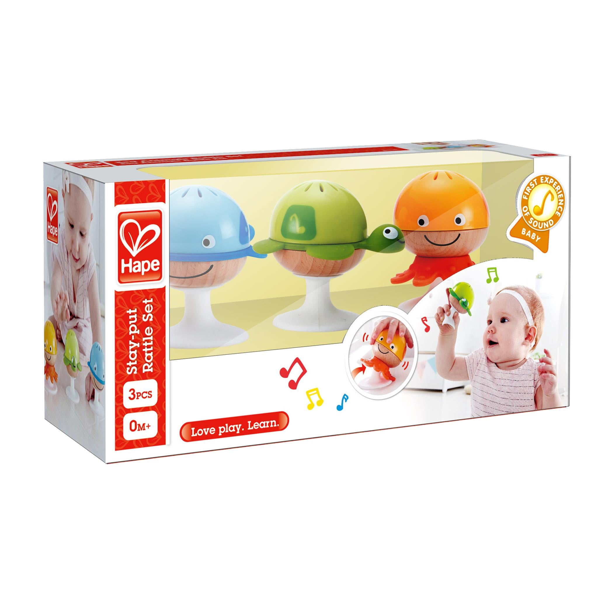 A packaged Stay Put Rattle Set by Hape, featuring three colorful rattle figures on stands, displayed in a clear plastic box with a white background.